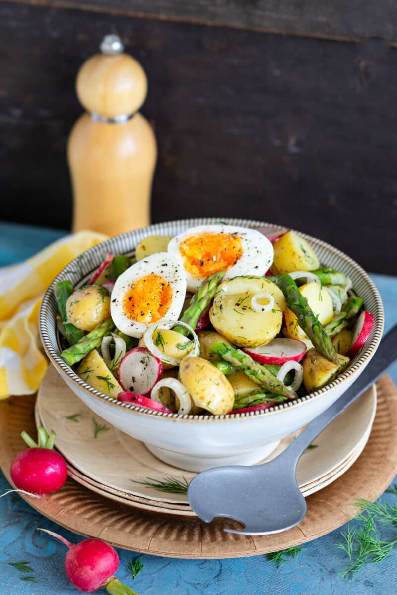 Dieser Kartoffelsalat mit Spargel, Radieschen und Ei bietet kulinarische Abwechslung auf dem Teller.